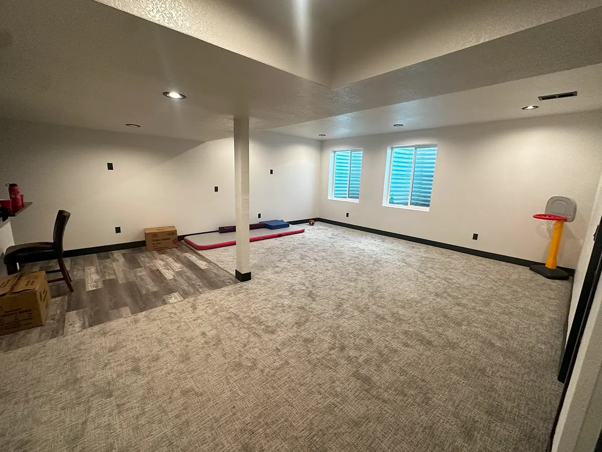 finished basement renovated white gray walls spotlights and beige carpet