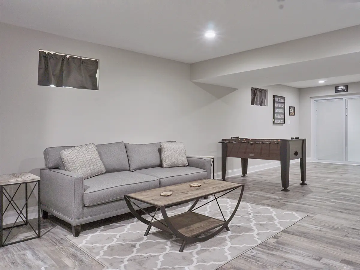 Colorado renovated Basement, gray walls, gray wooden floor, with football table