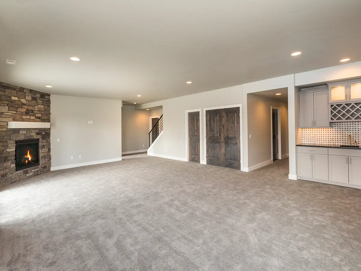 Colorado renovated basement, spotlights, brown carpet floor, wood doors and fireplace