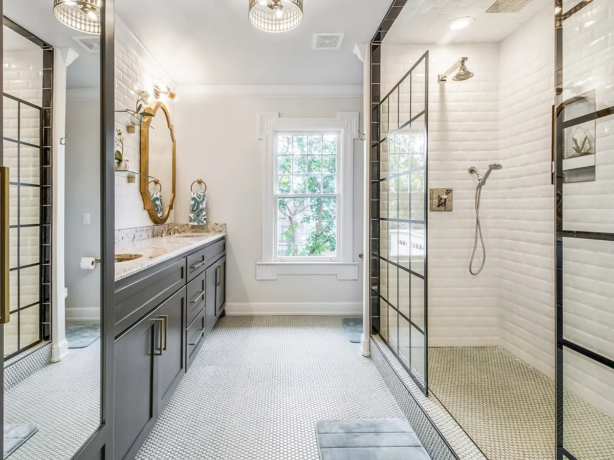 colorado renovated vintage bathroom, white walls, and white tile, black cabinets with white marble countertop, walk-in glass shower