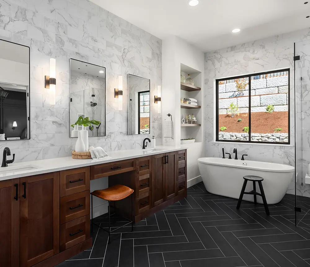 Centennial Remodeled bathroom with white pattern tile walls and black tile floor, wooden cabinets and white marble countertop, walk-in glass shower and mirrors
